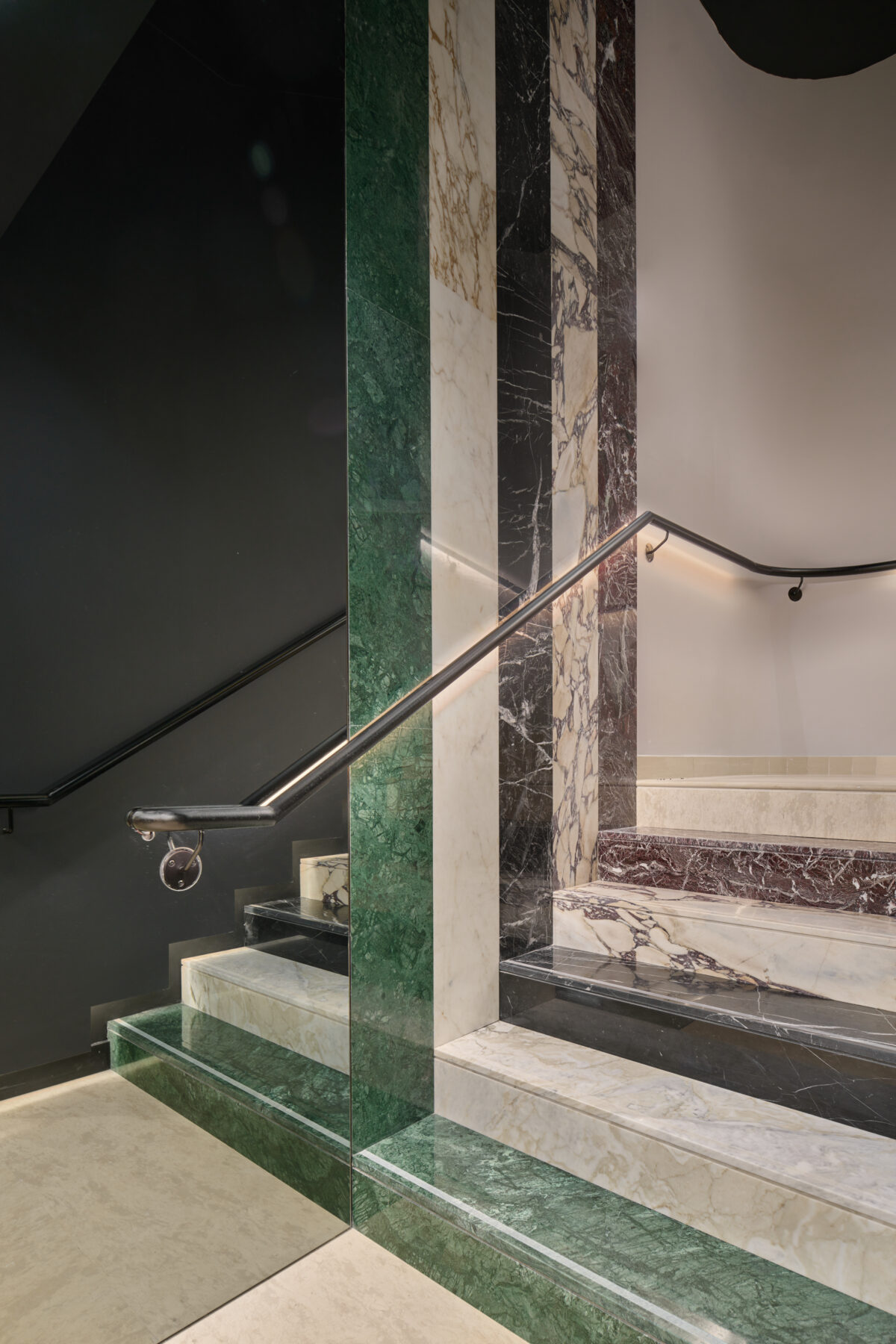 An image of a staircase in a hotel with various marble steps.